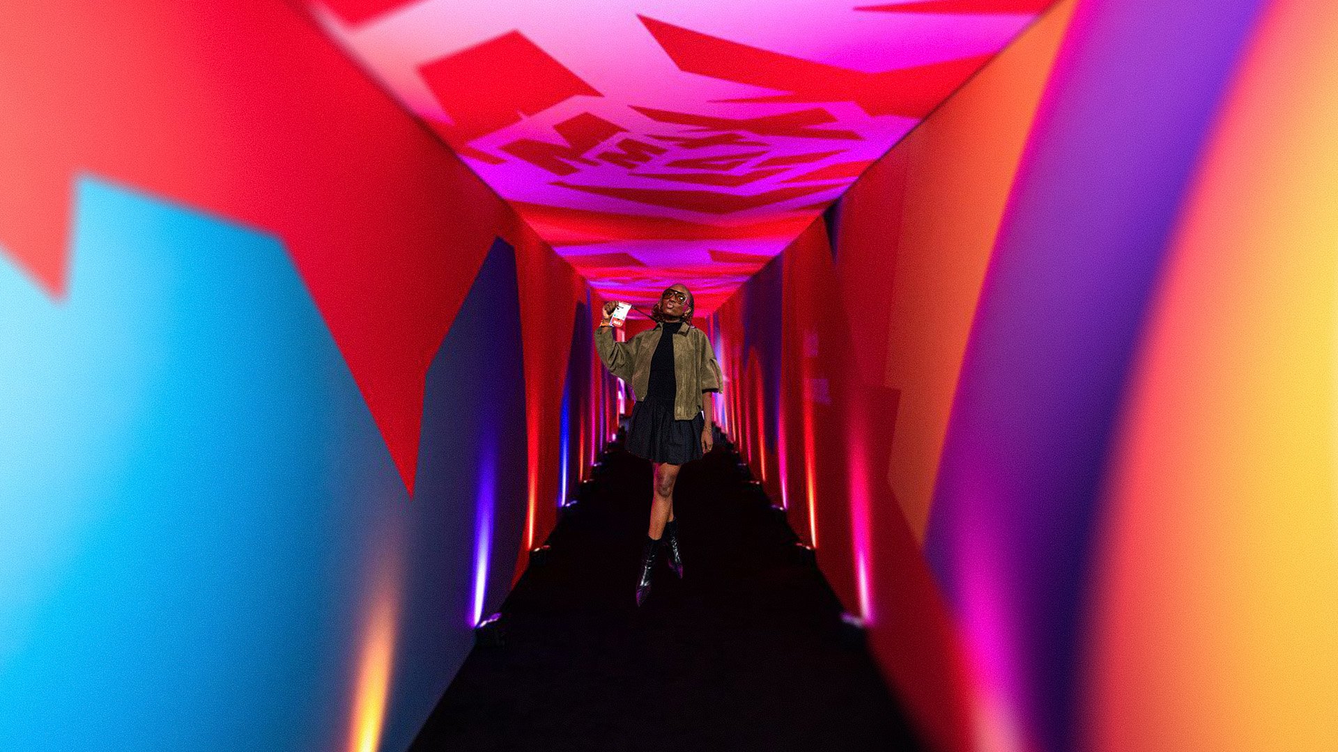 A guest in the color-drenched Adobe MAX corridor at Magic Box