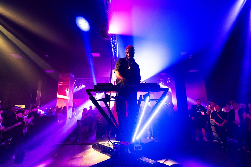 A DJ performing under stage lighting in an Activation Hall